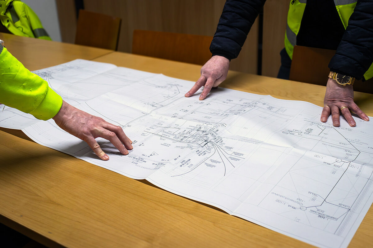 PTA Palvelut Oy työntekijät tutkivat rakennusten pohjapiirustuksia parhaan suunnitelman laatimiseksi